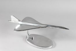 A CHROME TABLE MODEL OF CONCORDE on an oval base. 16ins high.