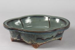 A CHINESE FLAMBE GLAZED POTTERY QUATREFOIL FORM BOWL, raised on four feet, 24cm x 18.5cm.