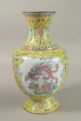 A CHINESE YELLOW GROUND ENAMELLED VASE, painted with a panel depicting an exotic bird and flora,