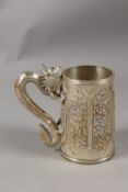 A VERY FINE CHINESE SILVER TANKARD, with cast dragon form handle, finely engraved with relief panels