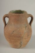 A 10TH CENTURY MIDDLE EASTERN UNGLAZED POTTERY TWIN HANDLE JUG, the interior with traces of green