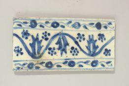 A RARE 18TH CENTURY TURKISH OTTOMAN KUTAHYA GLAZED POTTERY BORDER TILE, 20cm x 10cm.