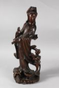 A 19TH CENTURY CHINESE CARVED ROOTWOOD GUANYIN FIGURE, stood upon a dragon-like beast with inset