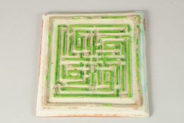 A VERY FINE AND UNUSUAL PERSIAN SAFAVID WHITE AND GREEN GLAZED POTTERY TILE, with raised Kufic
