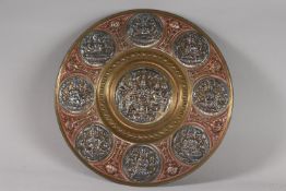 A SOUTH INDIAN TANJORE SILVER AND COPPER OVERLAID BRASS CHARGER, with Hindu deities, 31cm diameter.