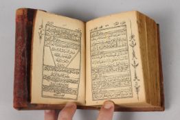 A FINE 19TH CENTURY POSSIBLY PERSIAN LEATHER BOUND SMALL QURAN, signed and dated, 1308 HD / 1890 AD,