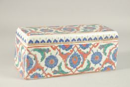 A TURKISH IZNIK GLAZED POTTERY RECTANGLAR LIDDED BOX, 28cm long.