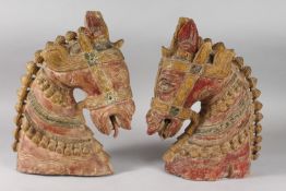 A LARGE PAIR OF 19TH CENTURY SOUTH INDIAN POLYCHROMED CARVED WOOD HORSE HEADS, each approx. 37cm