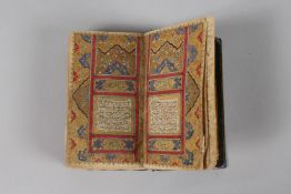 A VERY FINE 19TH CENTURY PERSIAN QAJAR POCKET QURAN, with finely lacquered floral cover, the