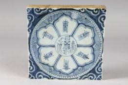 A CHINESE BLUE AND WHITE GLAZED POTTERY TILE, with symbolic flower motif and characters, 19cm