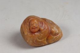 A CHINESE AMBER-COLOUR SOAPSTONE CARVING OF LUOHAN, 6cm wide.