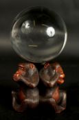 A VERY FINE JAPANESE CARVED WOOD OKIMONO OF THREE WISE MONKEYS WITH GLASS BALL, in the manner of