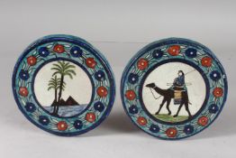 TWO UNUSUAL EARLY 20TH CENTURY PALISTIAN ARMENIAN CIRCULAR POTTERY TILES, 14cm diameter.