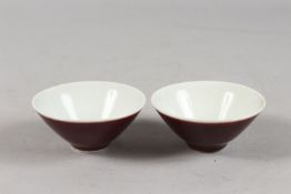 A SMALL PAIR OF CHINESE RED GLAZED PORCELAIN BOWLS, each with six-character mark to base, 9cm