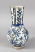 A 19TH CENTURY PERSIAN BLUE AND WHITE GLAZED POTTERY VASE, painted with floral motifs, 27cm high.