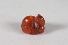 A JAPANESE POSSIBLY BAKELITE / AMBER OR RESIN NETSUKE OF A MOUSE, 3.5cm.