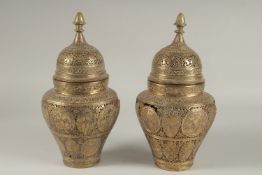 A PAIR OF PERSIAN QAJAR OPENWORKED LIDDED BRASS JARS, decorated with figures and floral motifs, 28cm