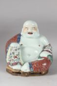 A LARGE CHINESE PORCELAIN LAUGHING BUDDHA, on a shaped stand, the robes painted with flowers and