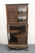 A LATE 19TH CENTURY CARVED HARDWOOD DISPLAY CABINET with two decoratively carved panel doors, a