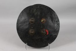 AN 18TH CENTURY INDIAN SHIELD, with three steel bosses (one missing), 42cm diameter.