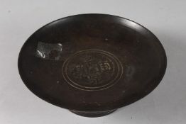 A CHINESE BRONZE FOOTED CIRCULAR DISH, with central characters, 18cm diameter.