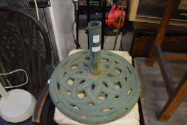 A cast iron parasol stand and a floor standing lamp.