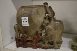 A Chinese carved soap stone vase depicting a monkey and birds.