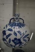 A Chinese blue and white moon flask painted with flowers.