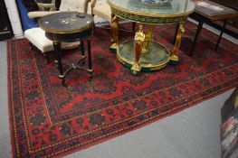 A large Turkish carpet, red ground with stylised decoration (cut and repaired), 380cm x 250cm.