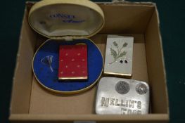 Two ladies cigarette lighter style atomisers and an advertising coin dispenser.