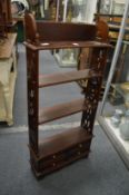 Mahogany hanging shelves with pierced sides and four small drawers.