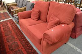 A modern red upholstered two seater settee.