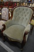 A Victorian mahogany framed button back armchair.