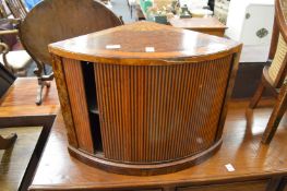 A satin inlaid burr yew hanging corner cabinet with tambour sliding front.