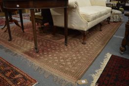 A large Afghan carpet, rust ground with stylised decoration, 350cm x 250cm.