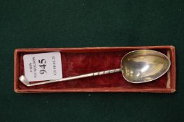 A silver golfing teaspoon.