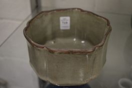 A Chinese celadon glazed dish with wavy rim.