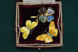 A pair of enamel decorated butterfly brooches and a clover leaf pendant.