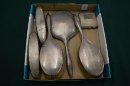 A silver compact and silver dressing table set.