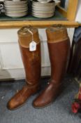 A pair of leather riding boots with wooden trees.