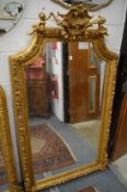 A large decorative gilt framed pier mirror with cherub and shell cresting.