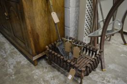 Cast iron fire grate, pair of brass fire dogs with two fireside tools.