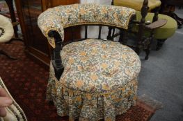 A Victorian horseshoe shaped and upholstered occasional chair with ebonised frame.