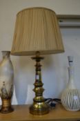A large brass table lamp and shade.