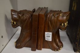 A pair of carved wood lion form bookends.