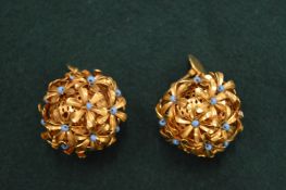 A pair of cluster flower form earrings.