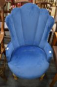 A blue velvet upholstered bedroom chair.