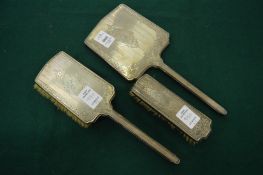 A three piece silver backed dressing table set engraved Sybil.