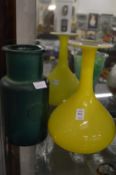 A stylish yellow glass vase and another vase.