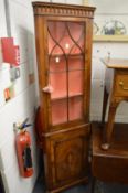A yew wood standing corner cabinet.